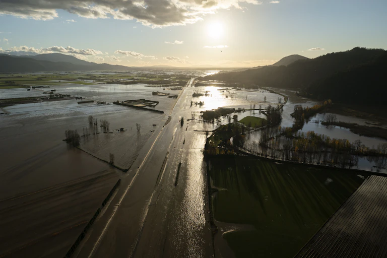 Aerial view of a flooded highway, homes and farmland