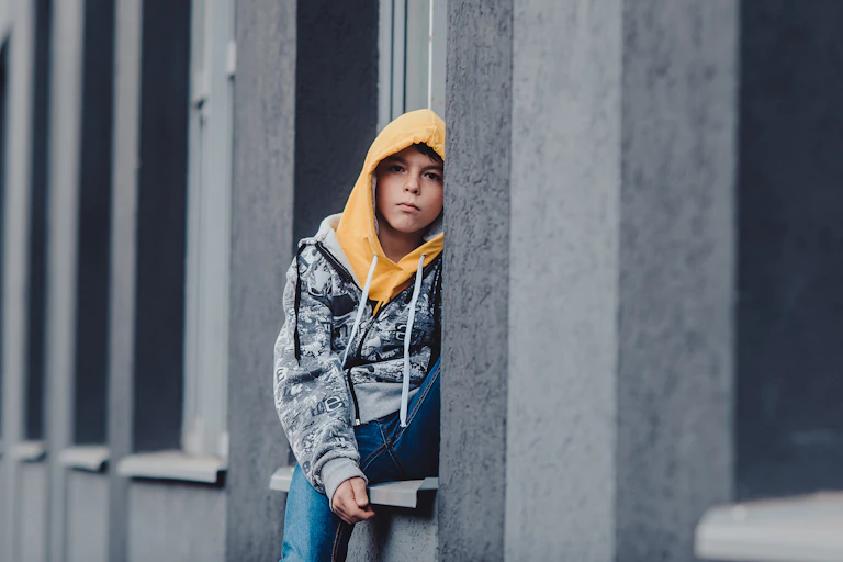 Pre-teen boy in hoodie.