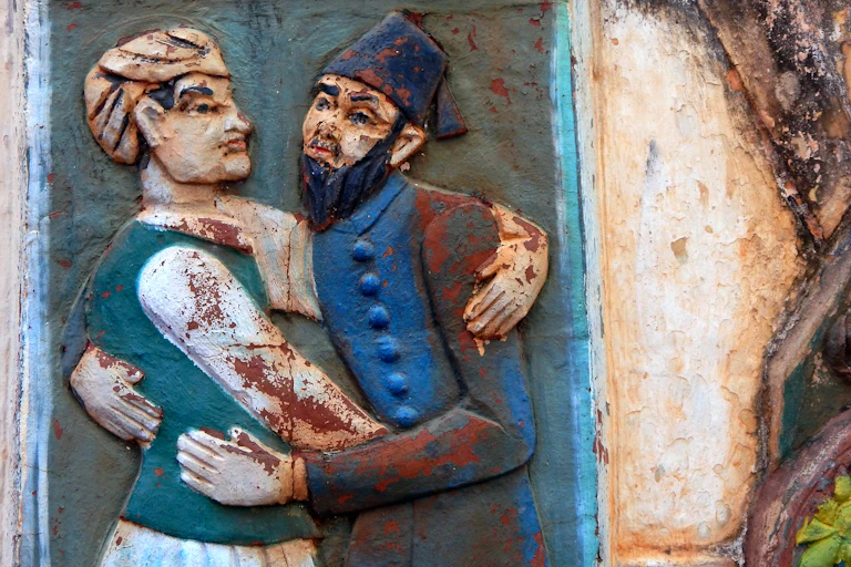 Wall art of Indian Hindu and Muslim hugging each other in religious tolerance and harmony.