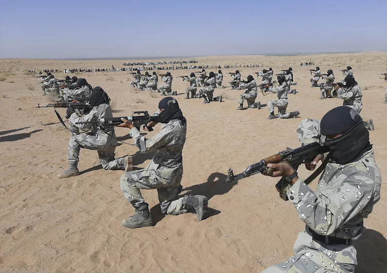 Soldats pointant leurs armes dans le désert