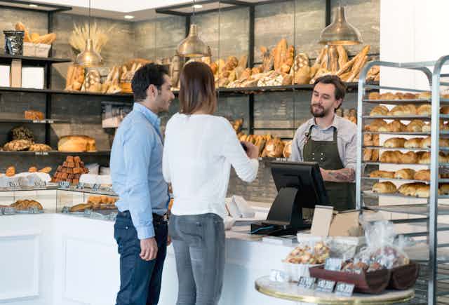 couple paying cashier at a bakery