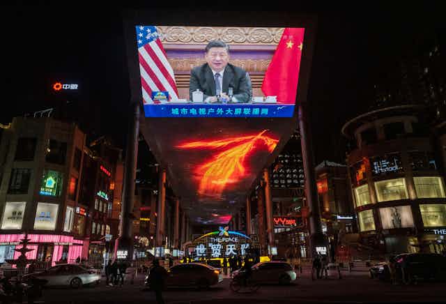  large screen displays Chinese President Xi Jinping during a virtual summit with United States President Joe Biden, not seen, during the evening CCTV news broadcast outside a shopping mall on Nov. 16, 2021, in Beijing.