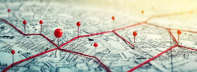 Red pins on a map of a city.
