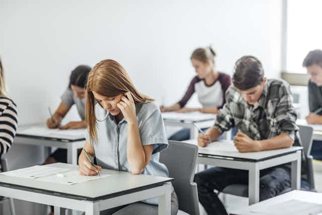 Teenagers in exam room doing test.