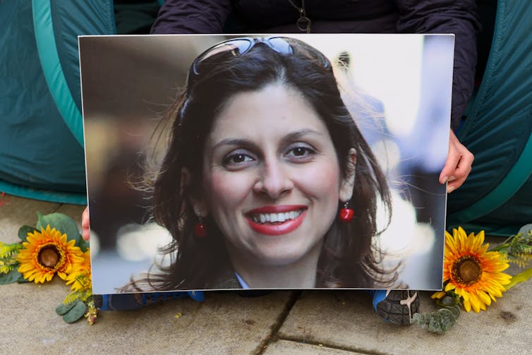 A photograph of Nazanin Zaghari-Ratcliffe flanked by two sunflower heads.