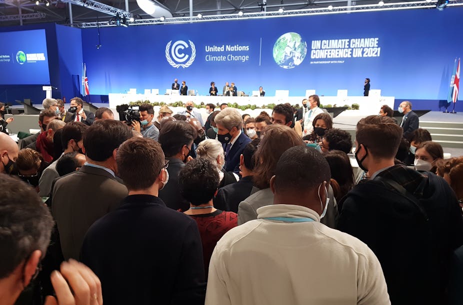 US climate negotiator John Kerry at the centre of a huddle of delegates at the COP26 climate summit in Glasgow.
