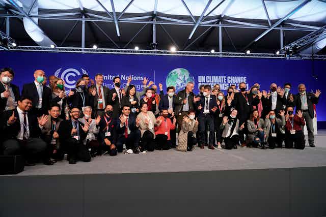 Groupe de personnes devant une affiche de la COP26