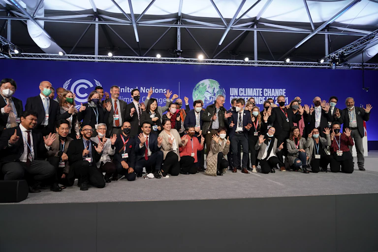 Groupe de personnes devant une affiche de la COP26