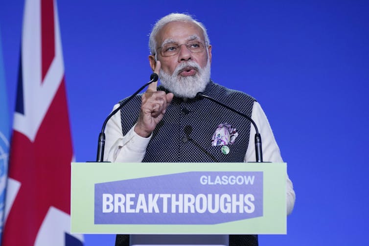 India's Prime Minister Narendra Modi speaks at a podium during an event during COP26.