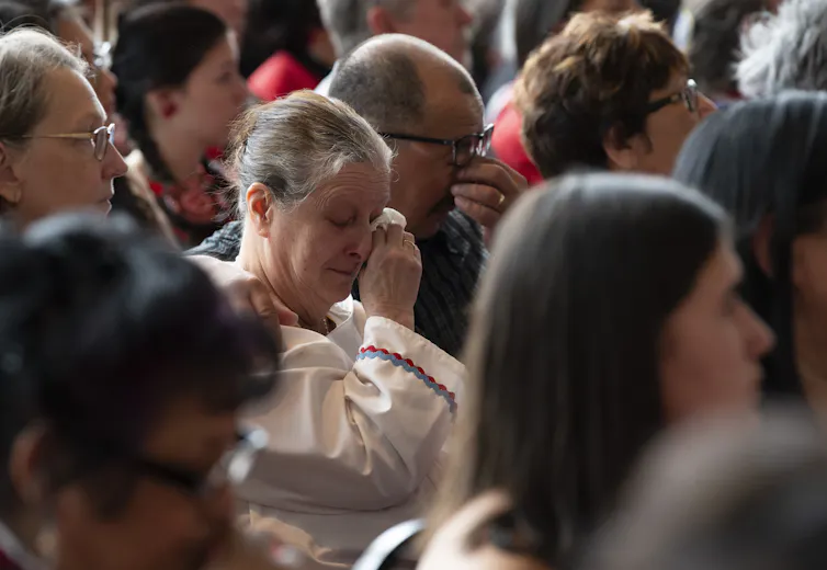 A man and women wipe their eyes of tears