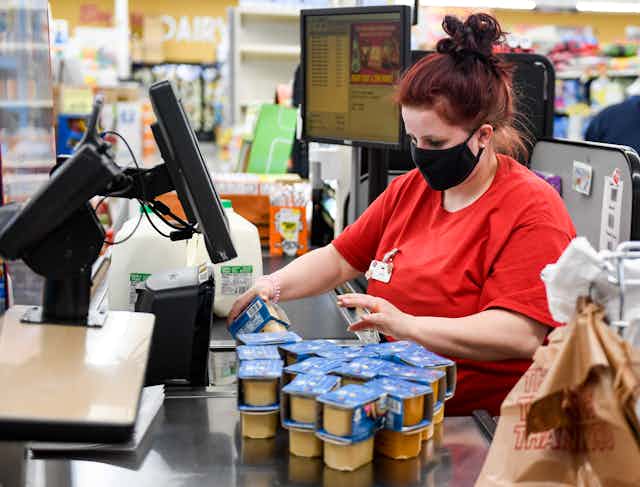 A supermarket cashier scans a customer's groceries.