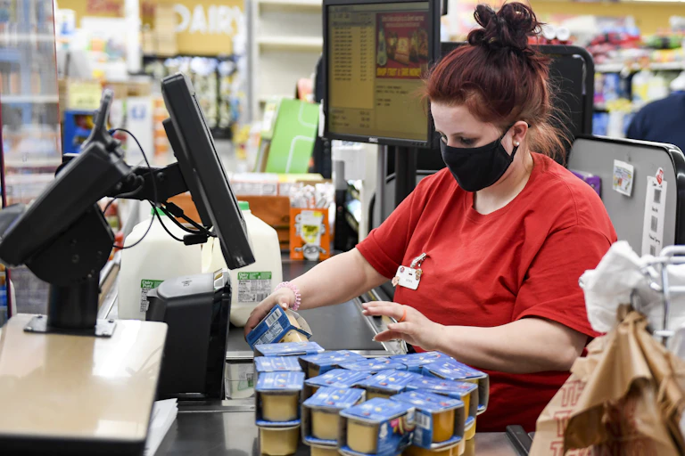 A supermarket cashier scans a customer's groceries.
