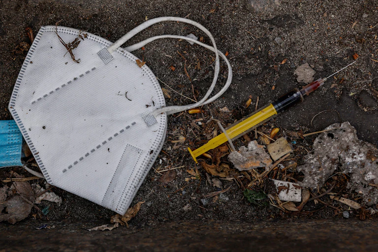 A discarded face mask and a syringe.