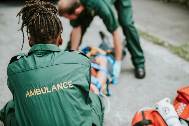 Two paramedics helping an injured patient