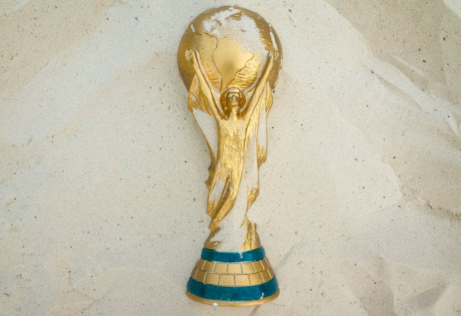 FIFA World Cup trophy in sand.