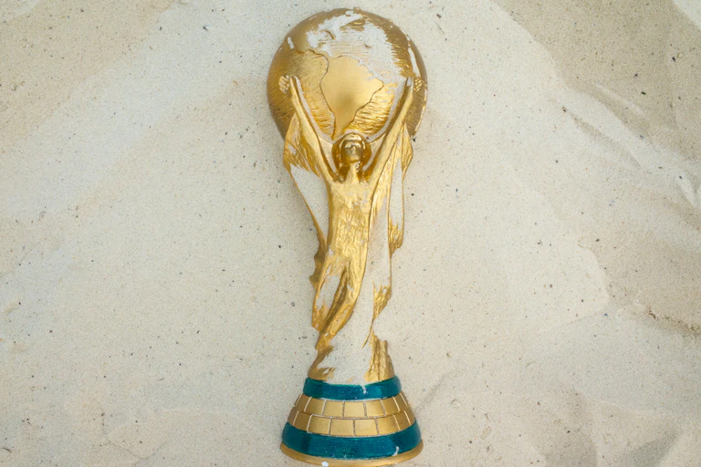 FIFA World Cup trophy in sand.