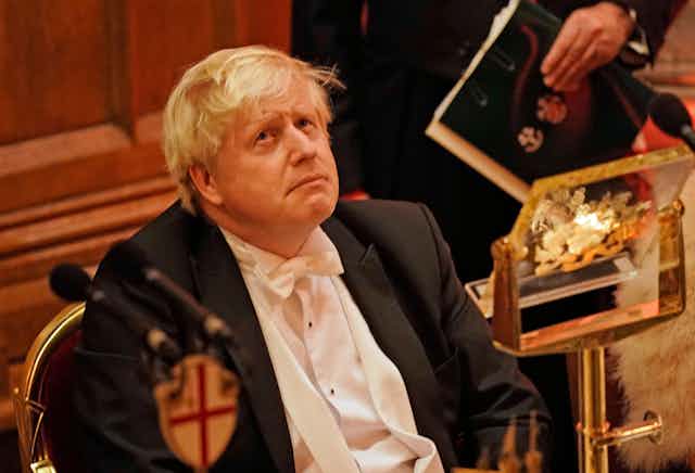 Boris Johnson wearing white tie at a dinner. 