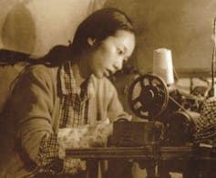 A woman at a sewing machine.