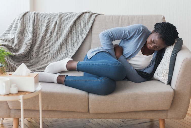 Woman curled up on a couch.