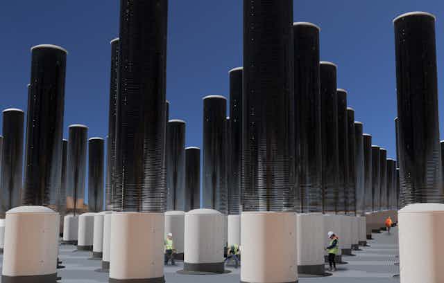 Rows of mechanical trees - tall cylinders that collect CO2 on stacks of discs.