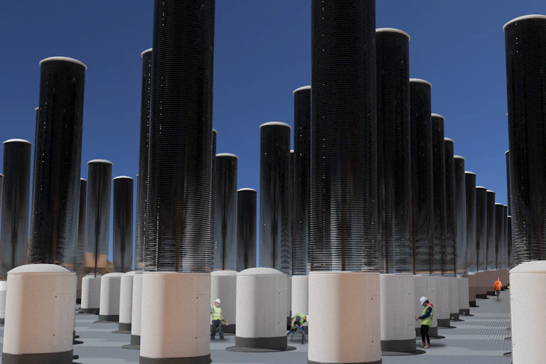 Rows of mechanical trees - tall cylinders that collect CO2 on stacks of discs.