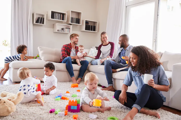 Two sets of parents and toddlers together on a play-date