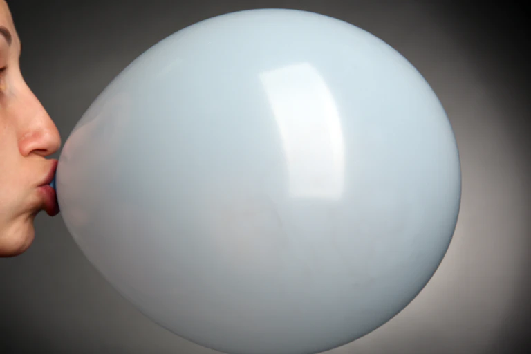 Woman blowing up balloon