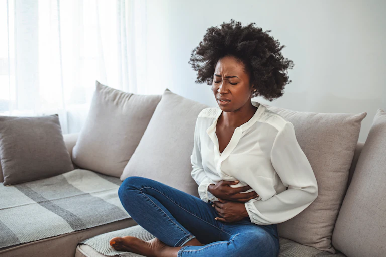 Woman holding her stomach in pain.