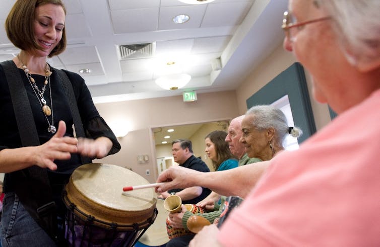 Une musicothérapeute utilise un tambour avec une femme atteinte d’Alzheimer