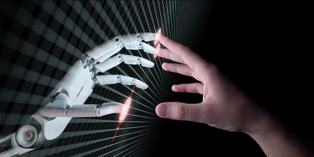 the fingertips of a robot hand and a human hand touch at a screen