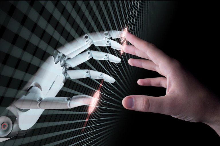 the fingertips of a robot hand and a human hand touch at a screen