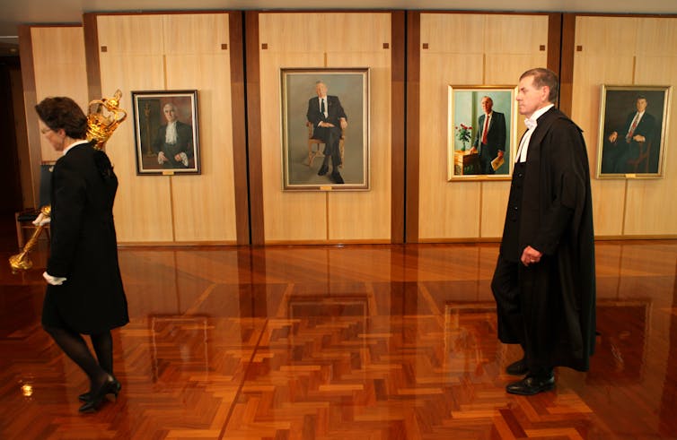 Former speaker Peter Slipper follows the ceremonial procession past the portraits of previous speakers : Sir Billy Snedden, Dr Harry Jenkins, Leo McLeay, and Stephen Martin.