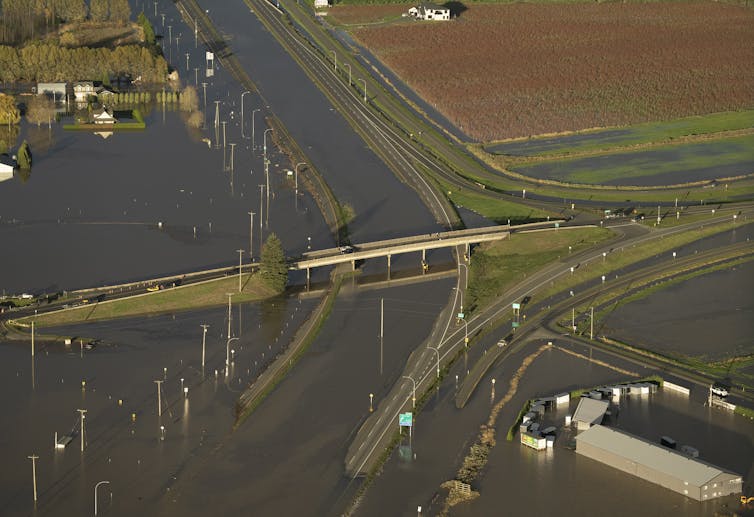 An overpass goes over a flooded highway.