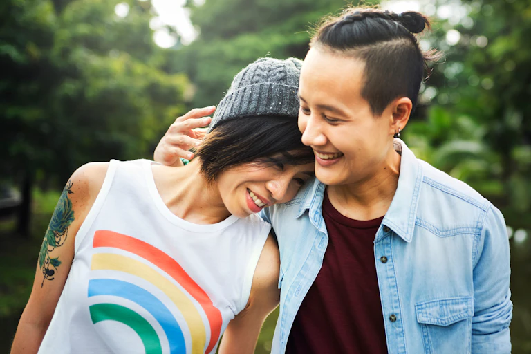 A couple smile and lean towards each other.