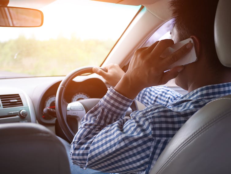 A man speaking on the phone while driving.
