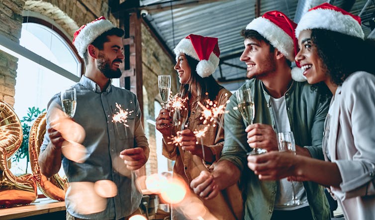 People in Christmas hats at a bar having a work Christmas party