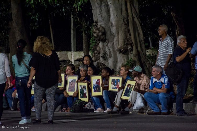 Cubans, some holding portraits of the late Fidel Castro, mourning the death of the president in Havana's Plaza de la Revolución, November 2016.