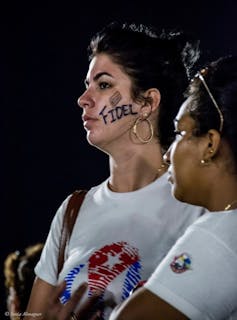 Two women, one with face painting honouring the late Cudan president Fidel Castro.