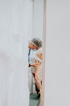 A health professional administers a vaccine to an older person