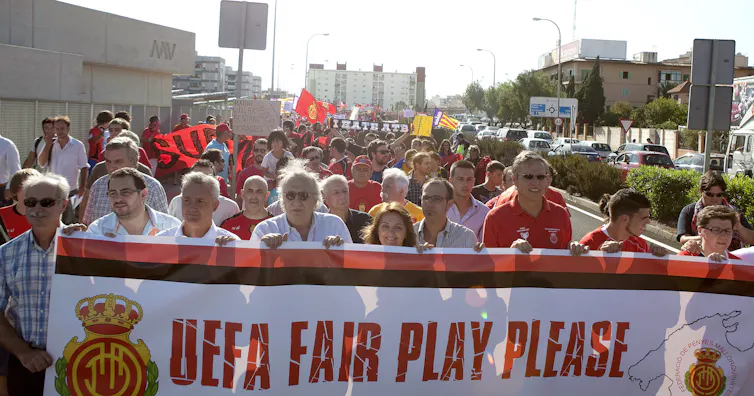 Supporters of Real Mallorca marching with banner.