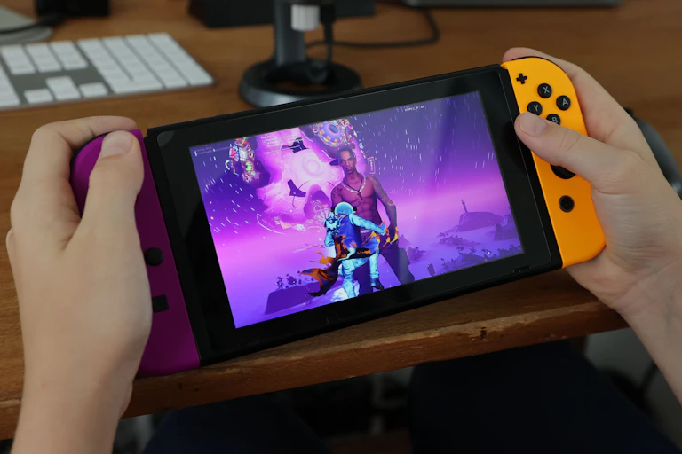 A pair of hands holding a handheld videogame