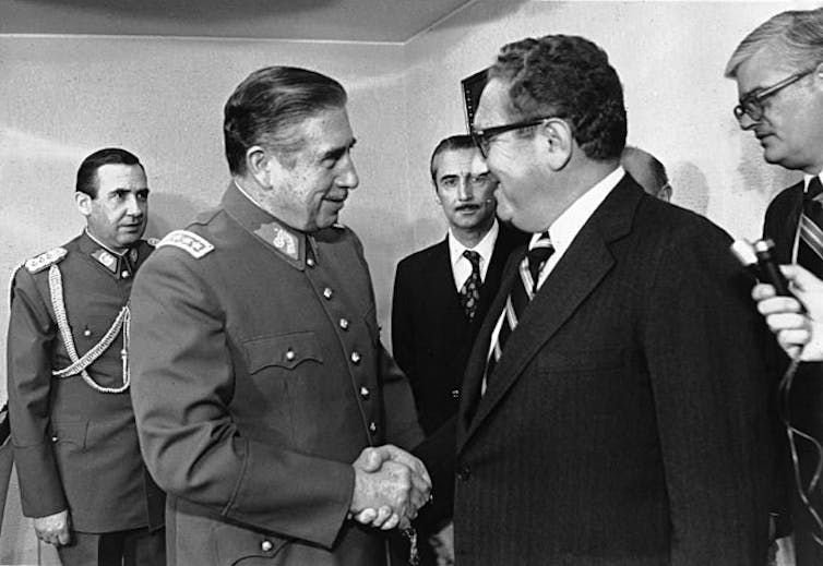 Chilean dictator Augusto Pinochet shakes the hand of US secretary of state, Henry Kissinger in 1976.