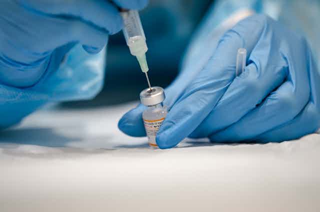 Une infirmière prépare une dose de vaccin Pfizer.