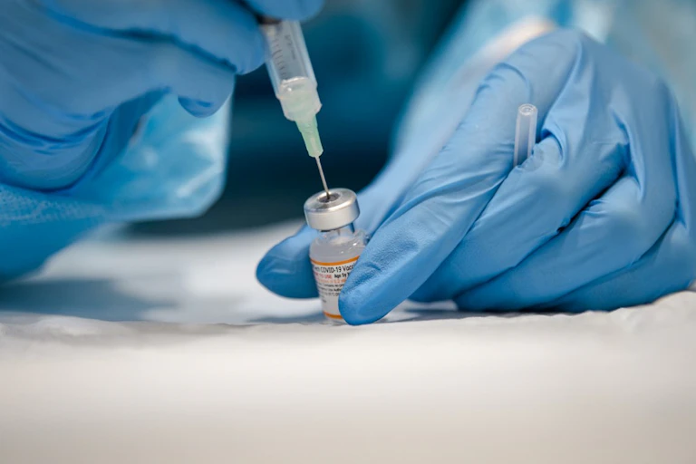 Une infirmière prépare une dose de vaccin Pfizer.