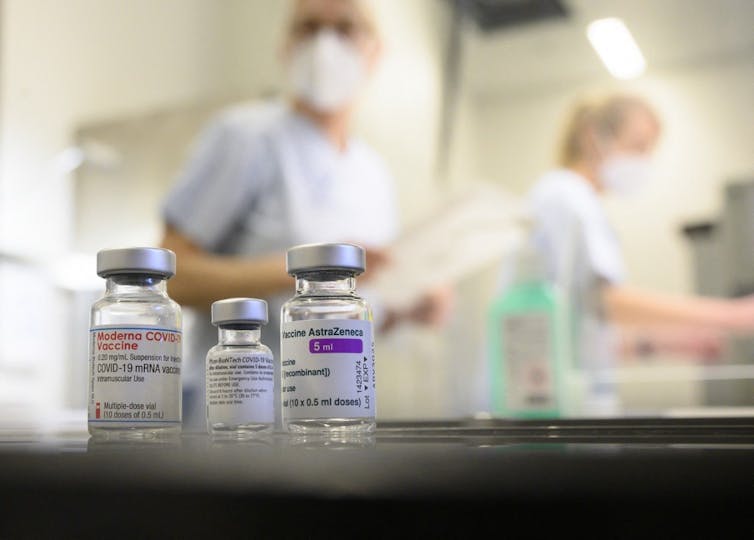 Trois fioles de Moderna, Pfizer et AstraZeneca