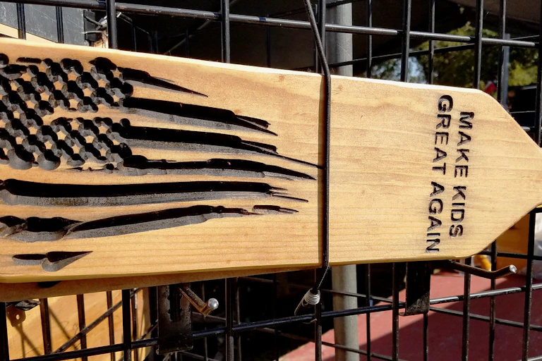 A spanking paddle to discipline children with the words "Make Kids Great Again".