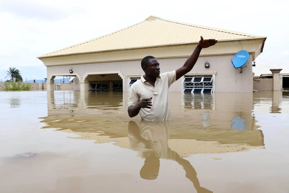 A man gestures next to his flooded house following heavy rain near the Nigerian town of Lokoja, in Kogi State, on September 14, 2018.
