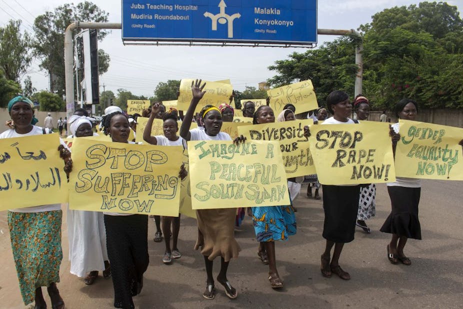 Women march carrying placards with messages demanding peace and their rights, on the streets of South Sudan's capital, Juba