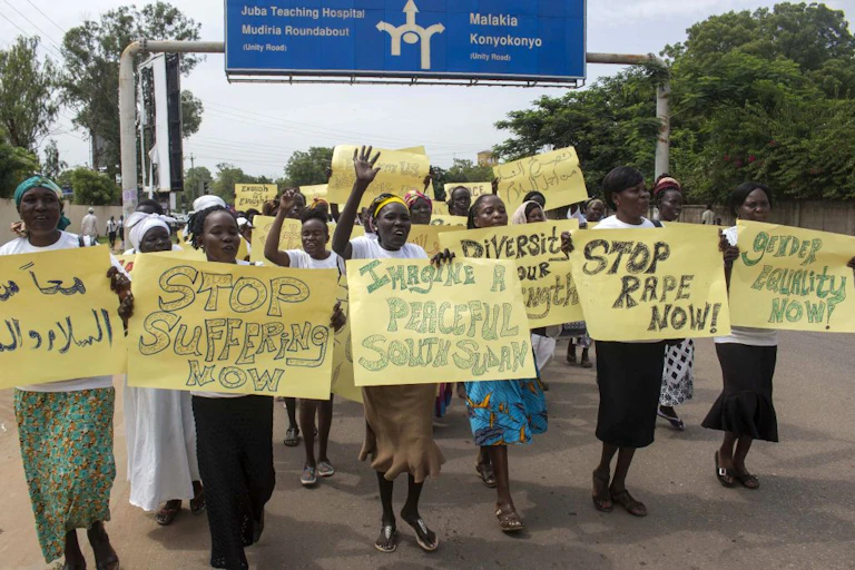 Women march carrying placards with messages demanding peace and their rights, on the streets of South Sudan's capital, Juba
