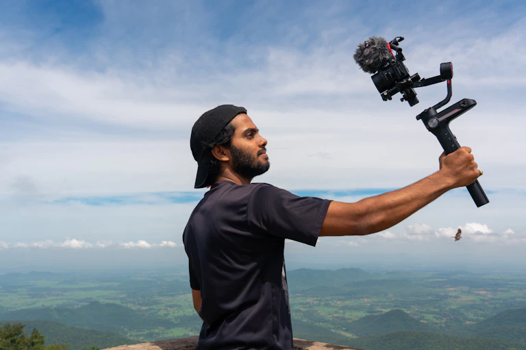 A young man holding up a camera that he is about to talk into.